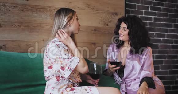 两个穿着睡衣的美女晚上在沙发上喝点酒她们心情愉快视频的预览图