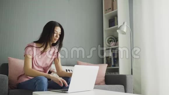 在家拿着笔记本电脑工作的疲惫的女人视频的预览图