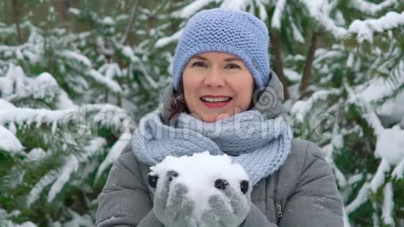 快乐的女人在松林中缓慢地吹雪视频的预览图