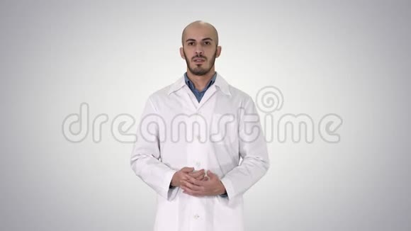 穿着医用外套的阿拉伯医生用手在梯度背景上说话和展示一些东西视频的预览图