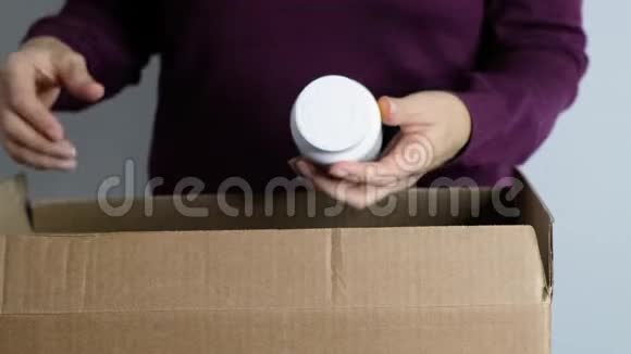 女人的手从盒子里拿出维生素药物和药丸闭上眼睛网上购物视频的预览图