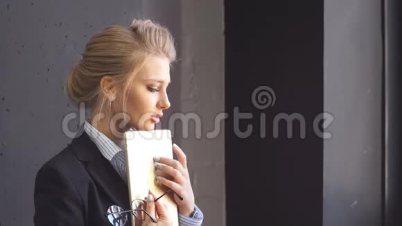 一位迷人的年轻商务女士在咖啡店的肖像手里拿着一块平板电脑视频的预览图