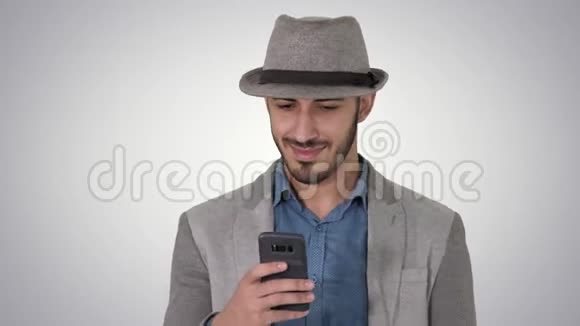 智能休闲阿拉伯男子使用智能手机而走在梯度背景视频的预览图