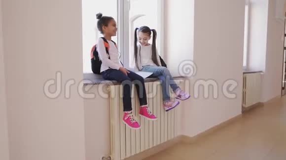 两个快乐的孩子坐在窗台上笑视频的预览图