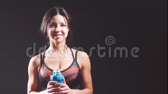 画室里一个活泼开朗的女孩的肖像背景是黑色的有一瓶水视频的预览图