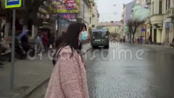 一个女人穿过马路检查是否有人在附近病毒流行大流行Covid19视频的预览图