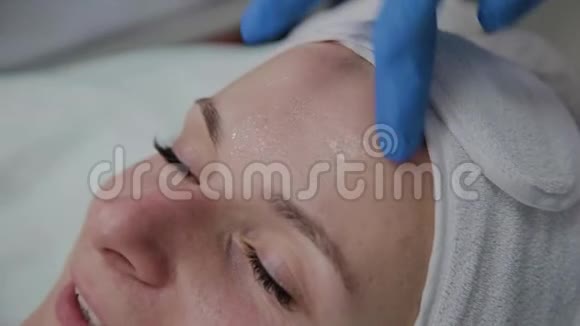 专业美容师将血清应用于患者面部视频的预览图