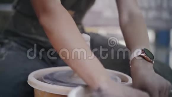 特写镜头女陶工把黏土的手浸在陶圈上视频的预览图