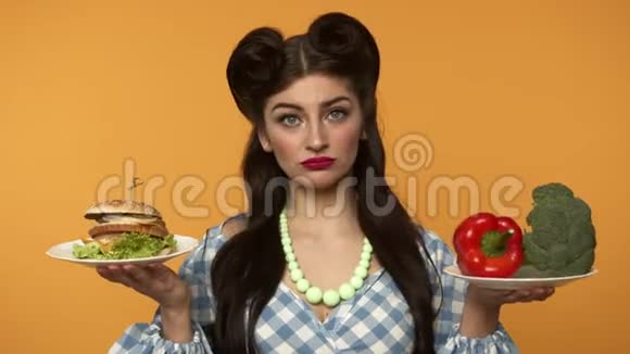 不自信的女人拿着汉堡和新鲜蔬菜视频的预览图