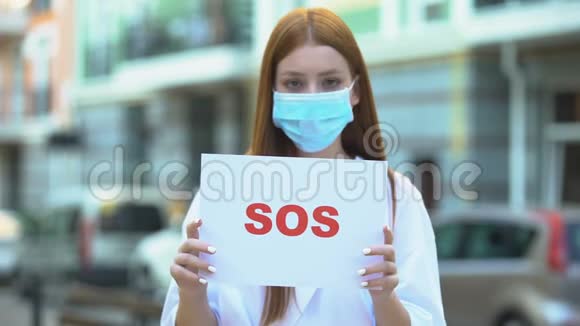 戴防护面罩的年轻女性持有sos标志空气污染温室气体视频的预览图