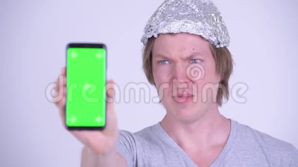一个精神紧张的年轻人戴着锡箔帽带着手机看上去很害怕视频的预览图