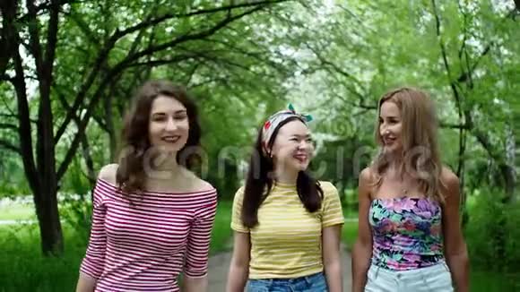 三个美丽的多民族女孩朋友一起笑着走公园视频的预览图