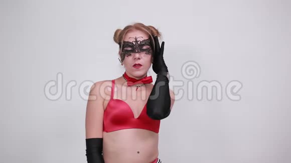 美丽的年轻女子戴着红色的胸罩和黑色的手套举起手来问候视频的预览图