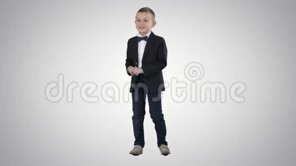 穿着正式服装的小男孩在渐变背景上说话和微笑视频的预览图