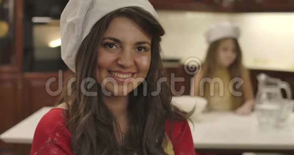 一位戴着厨师帽的白种人年轻女子的特写肖像看着镜头微笑着美丽的成人脸上有面粉视频的预览图