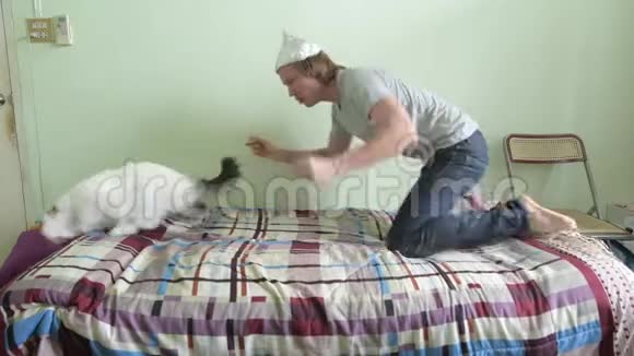 害怕的年轻人戴着锡箔帽子和猫在卧室里惊慌视频的预览图