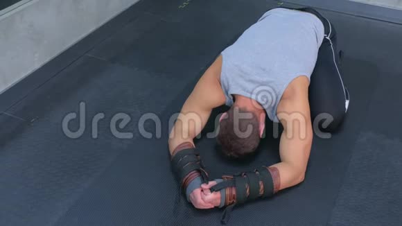 运动员在健身房使用教练进行肌筋膜伸展后休息在垫子上视频的预览图