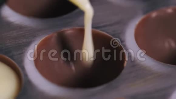 甜点从管道袋中填充牛奶巧克力模具宏观视频的预览图