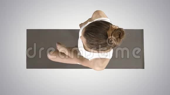 年轻迷人的女人练习瑜伽在梯度背景下做树锻炼视频的预览图