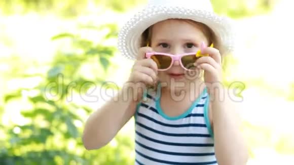 戴着帽子和太阳镜的快乐孩子微笑和笑表达幸福的情绪视频的预览图