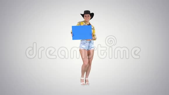 微笑漂亮的女牛仔拿着空板在渐变背景下跳舞视频的预览图