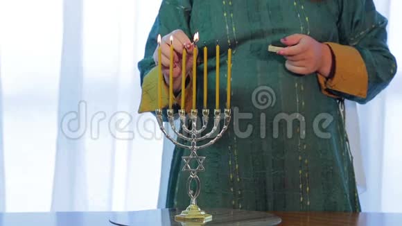 犹太妇女在节日前夕点燃了menorah视频的预览图