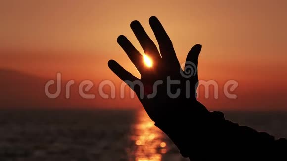 男子举起手臂和手在海滩日落视频的预览图