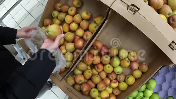 在杂货店市场上挑选新鲜有机苹果的女人纯有机食品素食视频的预览图