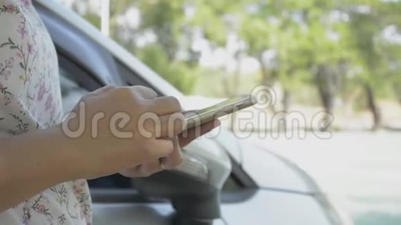 关闭女性手使用手机进行社会交流附近的汽车视频的预览图