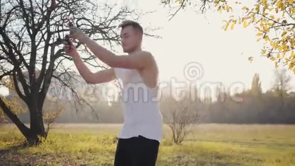 一个年轻的白种人男孩在日落时在秋天公园跳绳锻炼户外运动服装训练的人健康视频的预览图