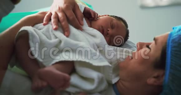 高加索夫妇在手术室里抱着新生婴儿的特写镜头视频的预览图