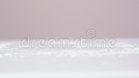 粉红色盛开的郁金香落在潮湿的桌子上喷水慢镜头特写视频的预览图