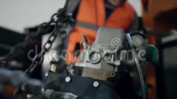 一名工人戴着头盔穿着工作服修理汽车发动机的轻微故障视频的预览图