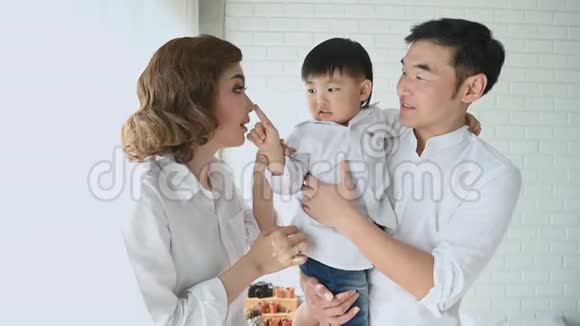 父母在家里的卧室里和一个半日本男孩玩幸福的家庭和宝宝概念多民族混血儿视频的预览图