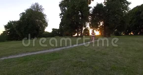 活跃的女人向日落阳光跑去空中无人机射击视频的预览图