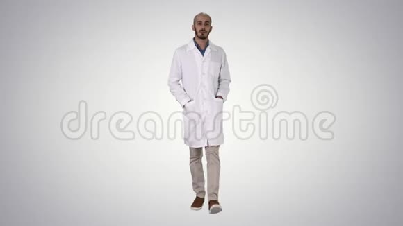 阿拉伯英俊的医生穿着他的制服走路双手在口袋里的梯度背景视频的预览图