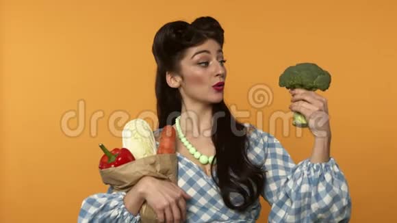 美丽的素食主义者女孩拿着纸袋带着蔬菜和西兰花微笑着视频的预览图