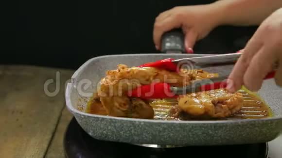 一个女人用钳子和鸡肉把蔬菜的碎片放到烤盘上然后把酱汁倒在上面视频的预览图
