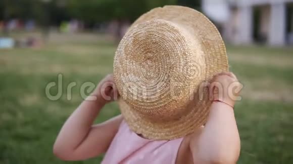 情绪化的快乐女孩戴着草帽笑着把她的脸藏在帽子后面年轻的女孩子喜欢夏天视频的预览图