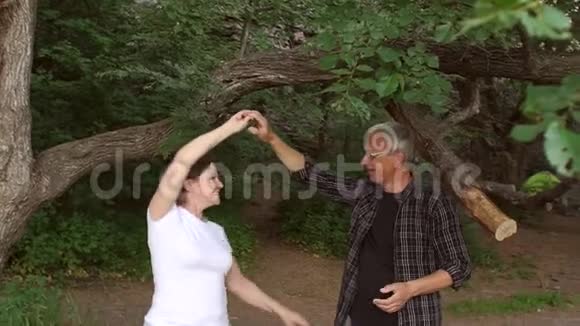 快乐成熟的情侣在公园跳舞慢动作视频的预览图