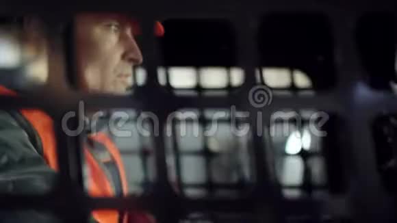 操作人员戴着头盔穿着工作服坐在新的装载机上从侧窗上钉着它视频的预览图