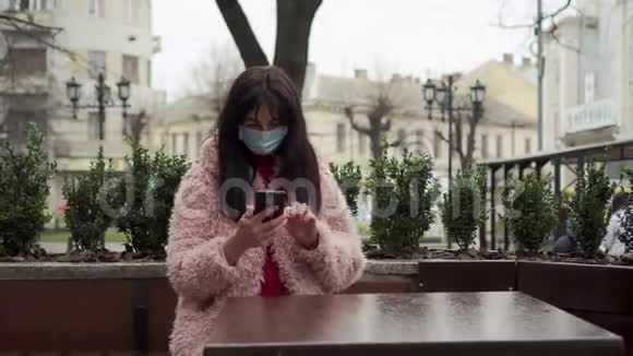 在街上戴防护面罩的年轻女人在城市隔离期间妇女独自居住病毒保护流行病视频的预览图