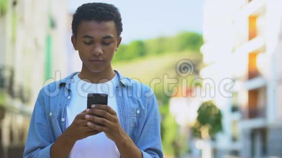 混合种族男孩震惊的通讯在他的智能手机促销优惠视频的预览图