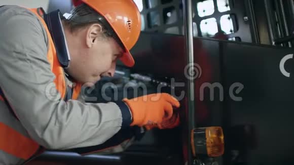 操作人员戴头盔穿工作服用流动摄影机修理小故障视频的预览图