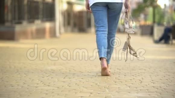 赤脚女孩走在街上双手拿着高跟鞋自由视频的预览图