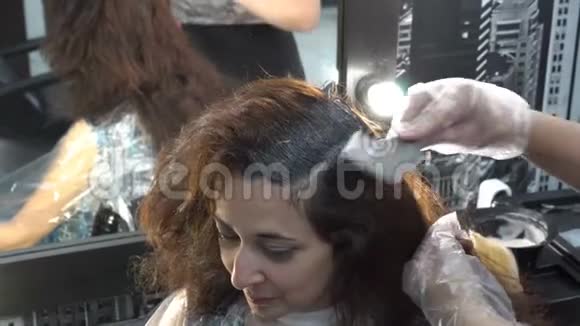 那个女孩头发是在理发店染的理发师用油漆刷涂在她的头发上快关门4K视频的预览图