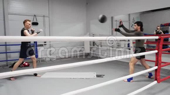 拳击手在健身房拳击训练时投掷球运动员在训练前热身心脏训练体育运动视频的预览图
