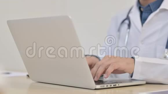 关闭男性医生在笔记本电脑上打字视频的预览图