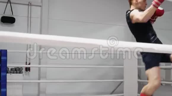 拳击手在拳击俱乐部的拳击场上训练圆场踢视频的预览图