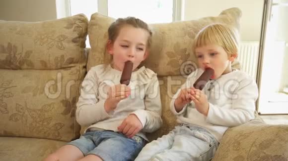 姐姐和哥哥坐在沙发上吃冰淇淋手持射击视频的预览图